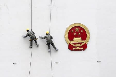 Workers paint a wall of a government building in Hangzhou, Zhejiang Province, China, March 26, 2016. REUTERS/Chance Chan/File Photo