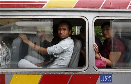 Passengers look out the windows of a bus as they travel around Yangon, July 3, 2013. REUTERS/Soe Zeya Tun