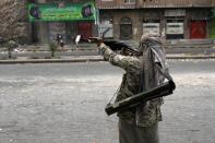 A Yemeni tribal gunman of the Popular Resistance Committees loyal to fugitive President Abedrabbo Mansour Hadi, raises his weapon in a street during clashes with Shiite Huthi rebels on April 18, 2015 in Taez in southwest Yemen