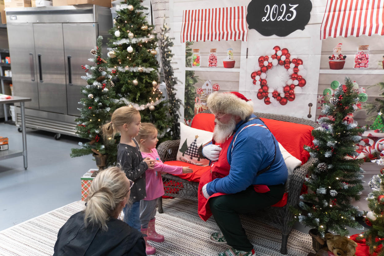 Two young girls meet with Santa Saturday at the Cake Company of Canyon.