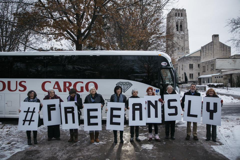 Riders showcase their #FREEANSLY signs before the bus ride from Saint Paul's Episcopal Church in Cleveland Heights, Ohio, to the federal court building in Ann Arbor, Michigan, on Wednesday. (Photo: Sean Proctor for HuffPost)