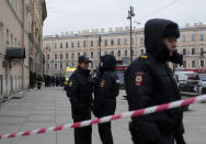 Russian police officers stand guard in a street after a explosion in St. Petersburg's subway, Russia, Monday, April 3, 2017. The subway in the Russian city of St. Petersburg is reporting that there are fatalities and several people have been injured in an explosion on a subway train. (AP Photo/Evgenii Kurskov)