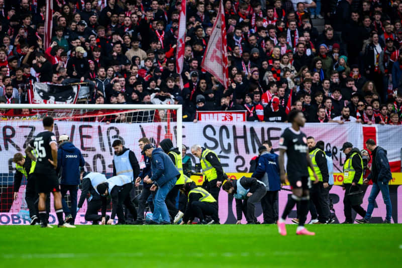 SC Freiburg fans protest against the German Football League's (DFL) plans to bring in investors and throw sweets, which are collected by stewards on the pitch during the German Bundesliga soccer match between SC Freiburg and Eintracht Frankfurt at Europa-Park Stadium. Tom Weller/dpa