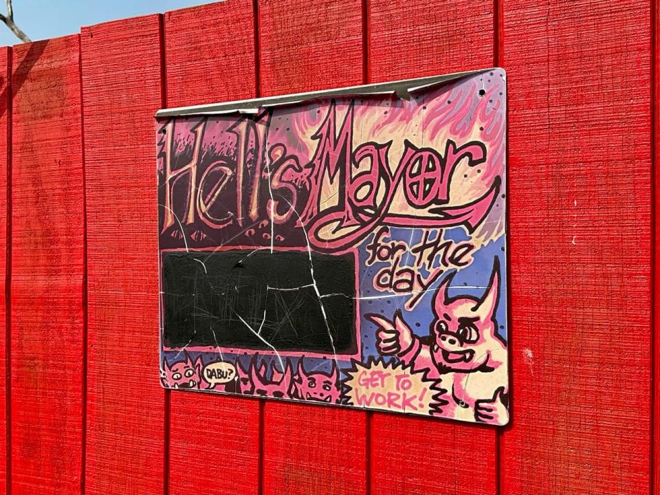 Chalkboard with "Hell's Mayor for the day" written on it with doodles of devils 