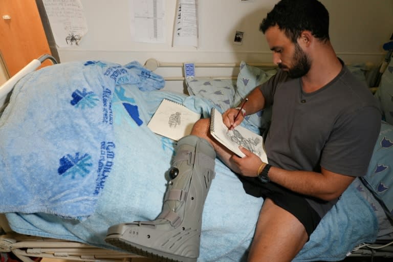 Barak, un soldado israelí herido en Gaza, dibuja en la cama del hospital Ichilov en Tel Aviv, el 22 de julio de 2024 (Sharon ARANOWICZ)