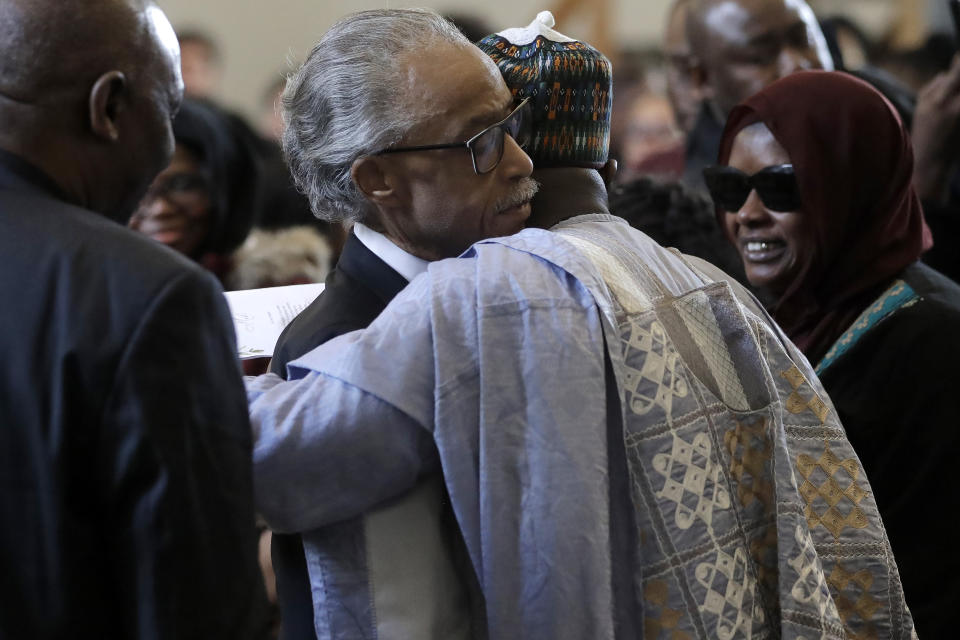 The Rev. Al Sharpton, center left, civil rights activist and founder of the National Action Network, hugs Imam Al Hassan Kamagtey, of Yonkers, N.Y., center right, as Omo Muhammed, right, mother of 19-year-old fatal shooting victim Mubarak Soulemane, looks on, Sunday, Jan. 26, 2020, during ceremonies to honor Soulemane's life, at the First Calvary Baptist Church, in New Haven, Conn. The Jan. 15, 2020 shooting by a Connecticut State Police trooper took Soulemane's life following a high-speed car chase, in West Haven, Conn. (AP Photo/Steven Senne)