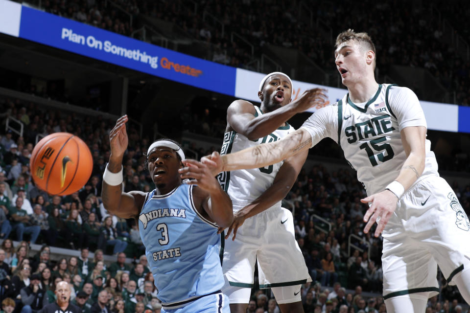 Indiana State guard Ryan Conwell (3), left, and Michigan State guard Tre Holloman, center, and Michigan State center Carson Cooper (15) reach for a rebound during the first half of an NCAA college basketball game, Saturday, Dec. 30, 2023, in East Lansing, Mich. (AP Photo/Al Goldis)