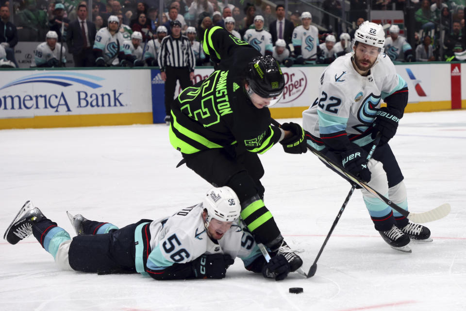 Seattle Kraken right wing Kailer Yamamoto (56), Dallas Stars center Wyatt Johnston (53), and Seattle Kraken right wing Oliver Bjorkstrand (22) battle for the puck in the second period during an NHL hockey game on Saturday, April 13, 2024, in Dallas. (AP Photo/Richard W. Rodriguez)