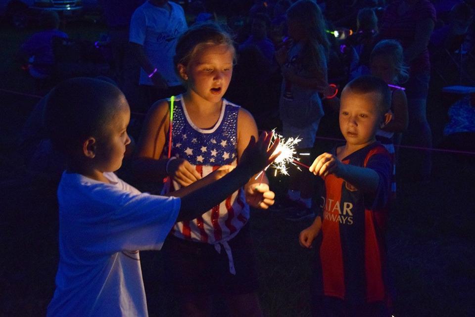 From left, Levi Reynolds, Kambell Crites and Charlie McCorvey light sparklers from a single flame in 2015. Sparklers are surprisingly dangerous and cause 75% of fireworks injuries.