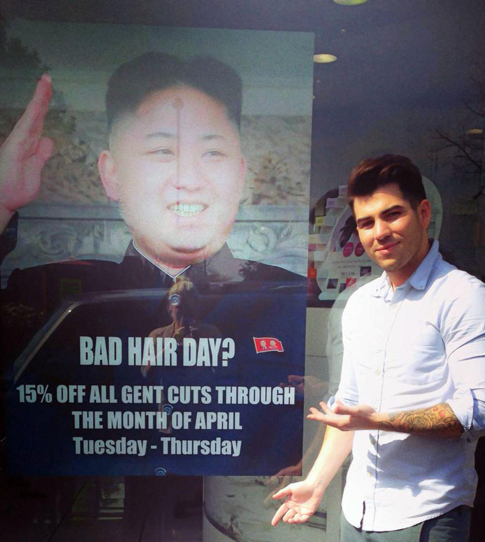 This undated photo provided by M&M Hair Academy in South Ealing, west London, shows barber Karim Nabbach standing next to a poster poking fun at North Korean leader Kim Jong-un unusual hairstyle. North Korean diplomats have asked the British government take action against a London hair salon’s poster poking fun at distinctively coiffured leader Kim Jong Un. The Foreign Office said Wednesday it had received a letter from the country’s embassy objecting to the poster, and was considering its response. The Evening Standard newspaper reported that the letter urged Britain to take “necessary action to stop the provocation.” Staff at M&M Hair Academy say they were visited by diplomats from the nearby embassy after putting up a poster featuring a picture of Kim - who sports a distinctive undercut - and the slogan "Bad Hair Day?" Police say they spoke to both parties and determined no crime had been committed. The embassy didn’t immediately respond to a request for comment. (AP Photo/M&M Hair Academy)