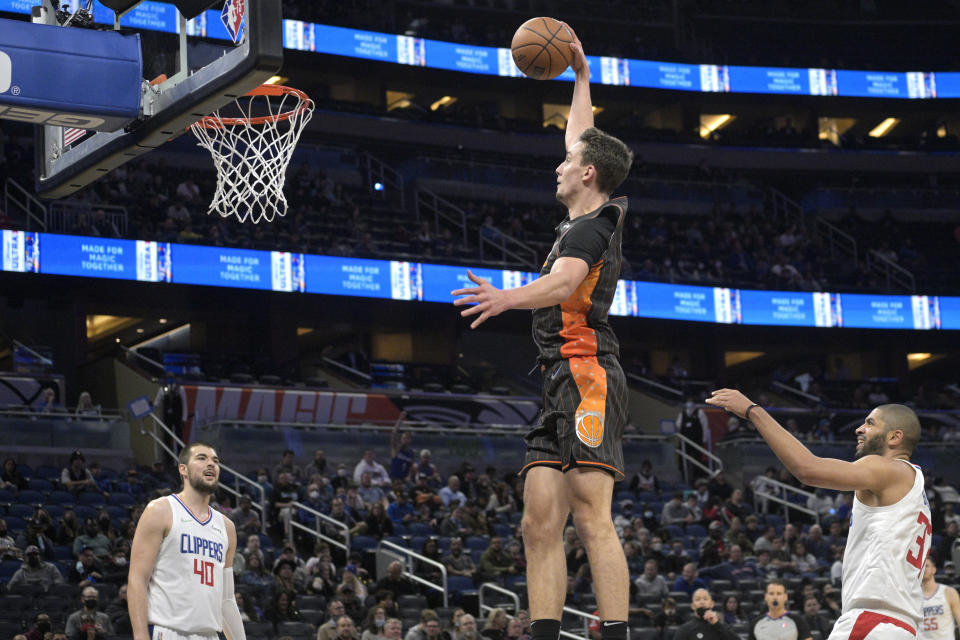 Orlando Magic forward Franz Wagner goes up for a dunk between Los Angeles Clippers center Ivica Zubac (40) and forward Nicolas Batum (33) during the first half of an NBA basketball game, Wednesday, Jan. 26, 2022, in Orlando, Fla. (AP Photo/Phelan M. Ebenhack)