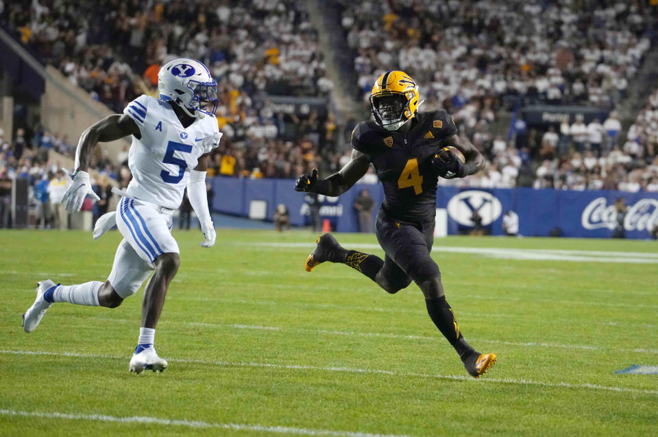 Sep 18, 2021; Provo, Utah, USA;  Arizona State Sun Devils running back Daniyel Ngata (4) is defended by BYU Cougars defensive back D'Angelo Mandell (5) on a 10-yard touchdown run in the third quarter at LaVell Edwards Stadium. Mandatory Credit: Kirby Lee-USA TODAY Sports