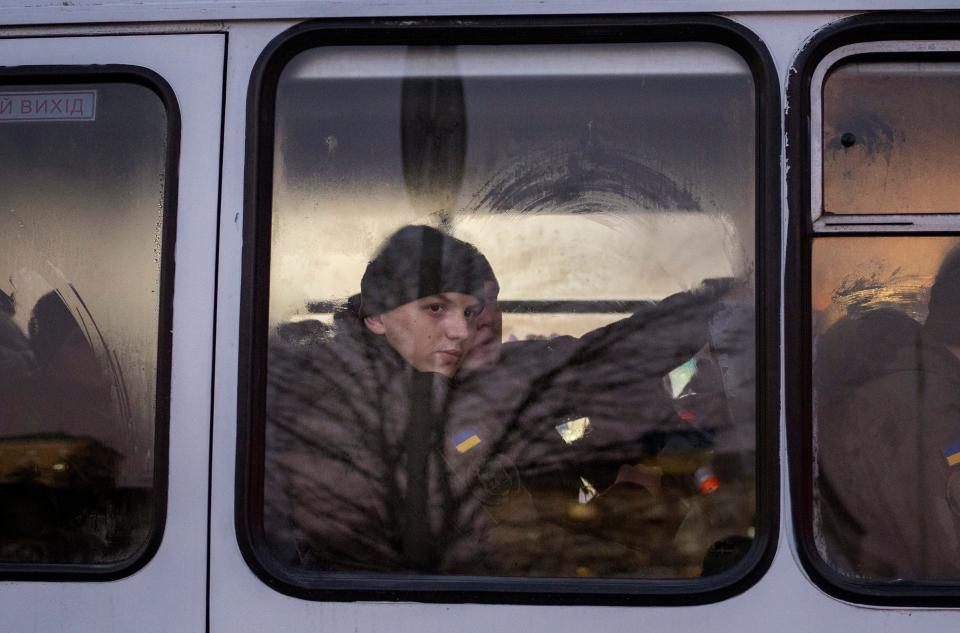 Ukrainian National Guard troops travel through Kyiv, the capital, on Monday as NATO troops headed to Eastern Europe and some Western governments urged their citizens and diplomats to leave Ukraine.
