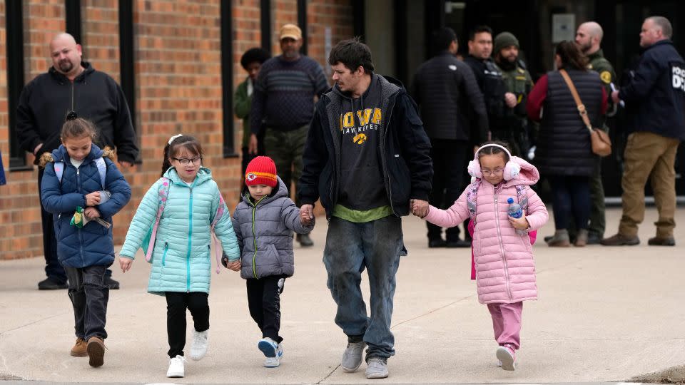 A man and children leave the McCreary Community Building after being reunited following a shooting at Perry High School on Thursday. - Charlie Neibergall/AP