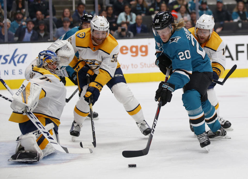 Nashville Predators goaltender Juuse Saros (74), Nashville Predators' Matt Irwin (52) battle for the puck against the San Jose Sharks' Marcus Sorensen (20) in the first period of an NHL hockey game in San Jose, Calif., Tuesday, Nov. 13, 2018. (AP Photo/Josie Lepe)