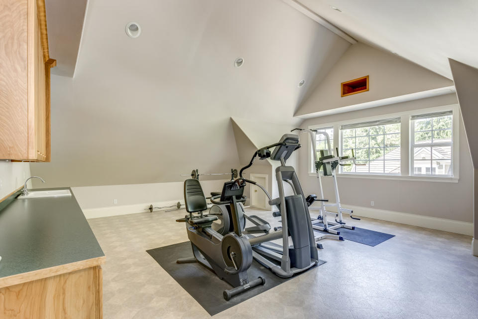 Well appointed home gym with vaulted ceiling in a large country house.