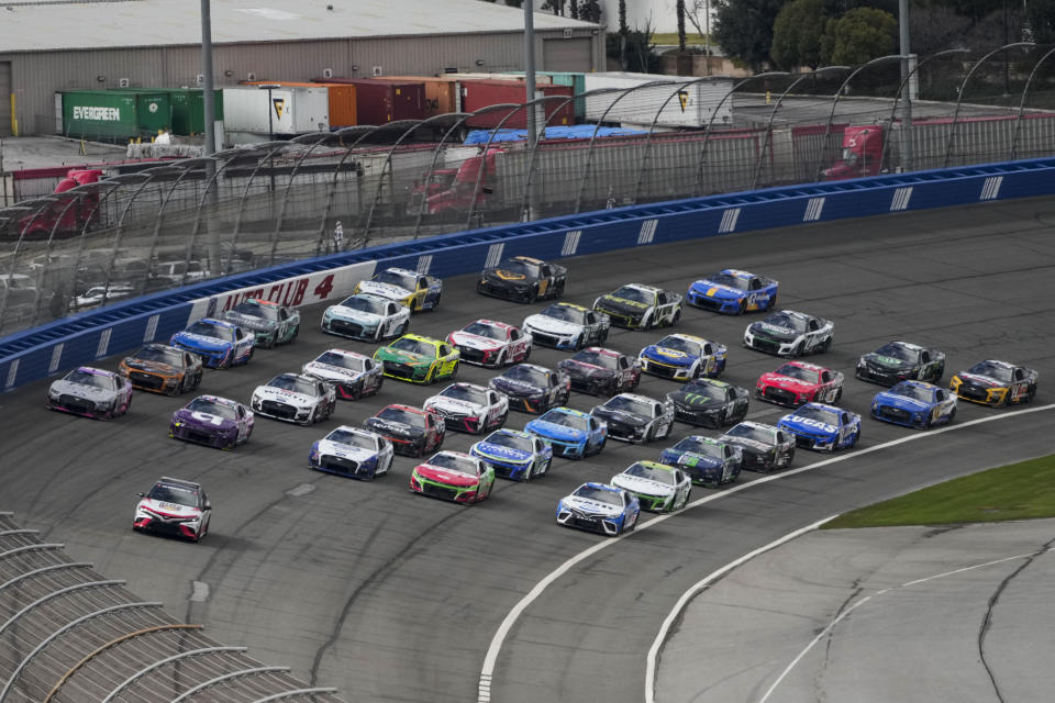 Cars drive in a five-line formation to acknowledge the fans before a NASCAR Cup Series auto race at Auto Club Speedway in Fontana, Calif., Sunday, Feb. 26, 2023. The track hosts its finalNASCAR Cuprace Sunday. (AP Photo/Jae C. Hong)