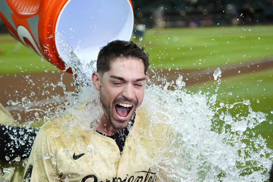 Arizona Diamondbacks' Randal Grichuk gets water dumped on him after his double drove in the winning run against the Chicago Cubs in a baseball game Tuesday, April 16, 2024, in Phoenix. The Diamondbacks won 12-11 in 10 innings. (AP Photo/Ross D. Franklin)