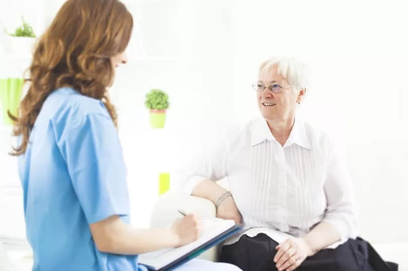 A doctor taking notes from a woman patient