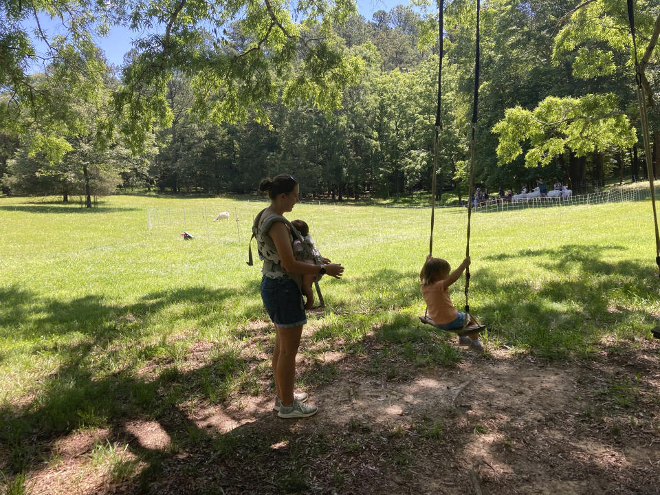 Joan Thanupakorn pushes her daughter, Nora, on a swing hanging from a tree during a Grow It wellness program for children at Spring Forest in nearby Hillsborough, N.C. on May 29, 2024. (Yonat Shimron/Religion News Service via AP)