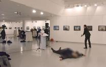 <p>Andrey Karlov, the Russian ambassador to Turkey, lies on the floor after being shot by a gunman (R) during an attack at a public event in Ankara. Photo: STRINGER/AFP/Getty Images</p>