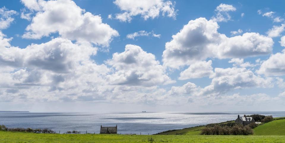 KG34JH Coast of Longrock in Cornwall with houses, sea, ship and many clouds in the summer sky.