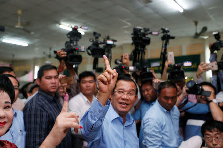 Cambodia's Prime Minister and President of the Cambodian People's Party (CPP) Hun Sen and his wife Bun Rany show their stained fingers at a polling station during a general election in Takhmao, Kandal province, Cambodia July 29, 2018. REUTERS/Samrang Pring