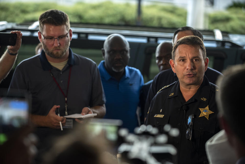 El jefe de policía Mike Williams, derecha, ofrece una conferencia de prensa el domingo 26 de agosto de 2018 luego de un tiroteo en Jacksonville, Florida. (AP Foto/Laura Heald)