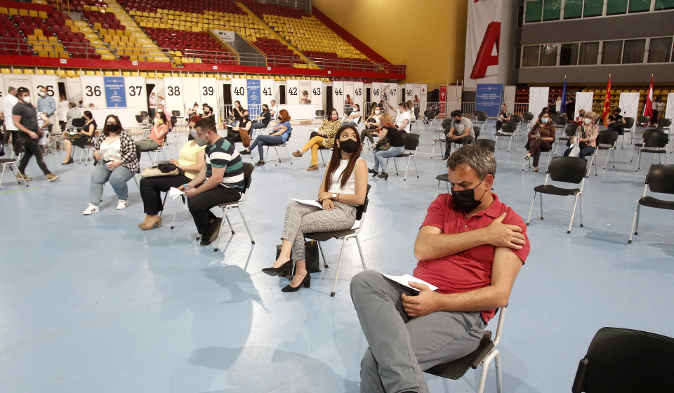 People wait after being vaccinated at the center for mass vaccination against COVID-19, at A1 Arena in Skopje, North Macedonia, on Tuesday, May 4, 2021. The European Union started delivering EU-funded coronavirus vaccines Tuesday to the Balkans, a region that wants to join the 27-nation bloc but where China and Russia have already been supplying the much-needed shots and making political gains. (AP Photo/Boris Grdanoski)