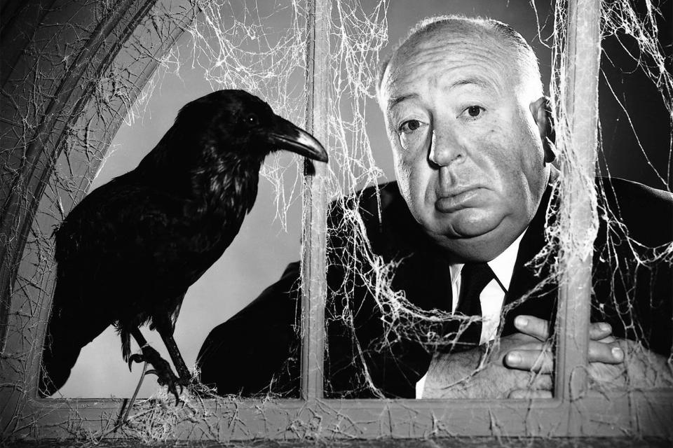 English director Alfred Hitchcock (1899 - 1980) posing at a cobweb-strewn window with a stuffed crow, in a promotional portrait for the TV anthology series 'Alfred Hitchcock Presents', circa 1955. (Photo by Silver Screen Collection/Getty Images)