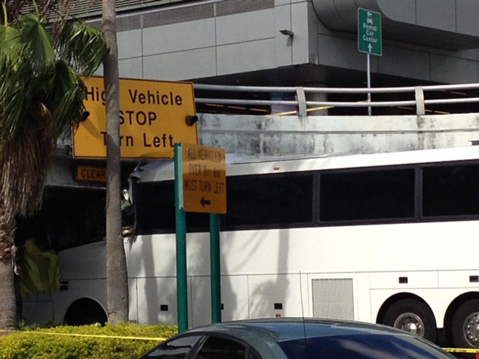 A bus is lodged into an overpass at the Miami International Airport on Saturday, Dec. 1, 2012. The vehicle was carrying over 30 people when it crashed into the structure. Authorities say buses typically are routed through the departures area, which has a higher clearance. (AP Photo/Suzette Laboy)