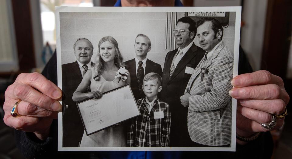 Janice Hanson, of Manitowoc, holds a vintage photo from 1973 showing 19-year-old Joan Bouril, Red Cross Water Safety Instructor, receiving a "Certificate of Merit" award from the American National Red Cross on July 5, 1973, at the Manitowoc Elk's Club for saving the life of 9-year-old Scott Hanson on Feb. 24, 1973.