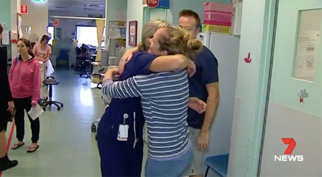 The Sadgroves are comforted by a hospital staff member. Picture: 7 News