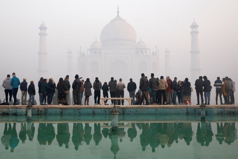 FILE PHOTO: Visitors look toward the Taj Mahal in January last year through morning air pollution