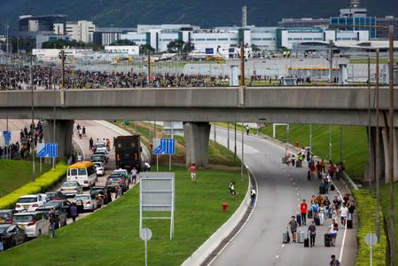 People try to get to Hong Kong International Airport as protesters gather in groups and try to block the highway, in Hong Kong