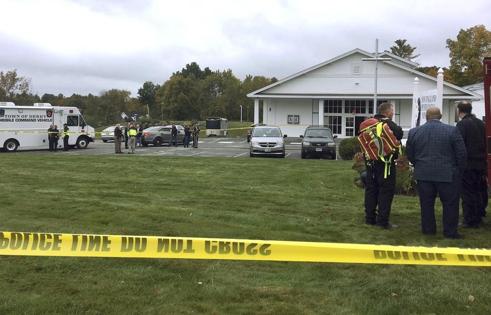 In this photo provided by WMUR-TV, police stand outside the New England Pentecostal Church after reports of a shooting on Saturday, Oct. 12, 2019, in Pelham, N.H. WMUR-TV reports that Hillsborough County Attorney Michael Conlon said a suspect is in custody. (Siobhan Lopez/WMUR-TV via AP)