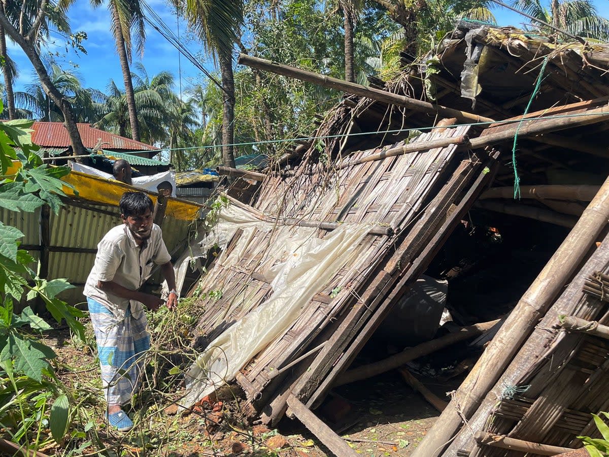 A man inspects his damaged home in Cox’s Bazar on 25 October 2023, following the landfall of Cyclone Hamoon. Nearly 275,000 people in Bangladesh fled to shelters as Cyclone Hamoon barrelled into the southeastern coast, killing at least three people, officials said (AFP via Getty Images)