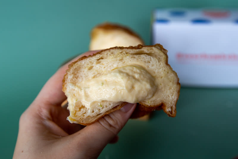 Hand holding cross-section of Lavender Lime Mascarpone bomboloni from Sourbombe Bakery