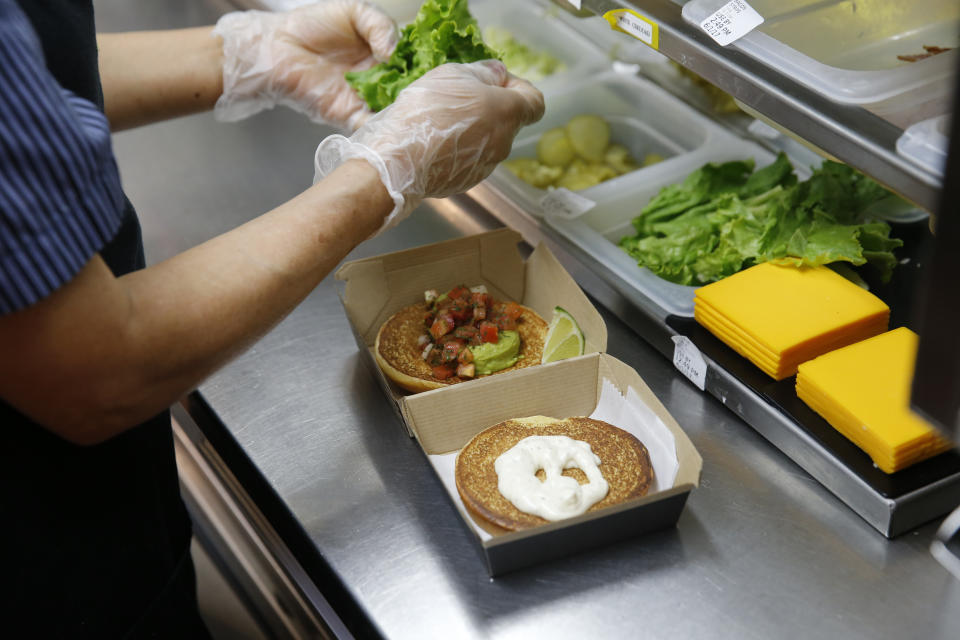 In this Thursday, June 1, 2017, photo, Silvia Ruiz prepares a specialty sandwich at a McDonald&#39;s restaurant in Chicago. The company that helped define fast food is making supersized efforts to reverse its fading popularity and catch up to a landscape that has evolved around it. McDonald&#x002019;s is still trying to shake its image for serving junk food and has made a high-profile pledge to offer healthier options. (AP Photo/Charles Rex Arbogast)