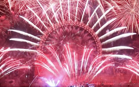 Fireworks light up the sky over the London Eye in central London during the New Year celebrations - Credit: PA