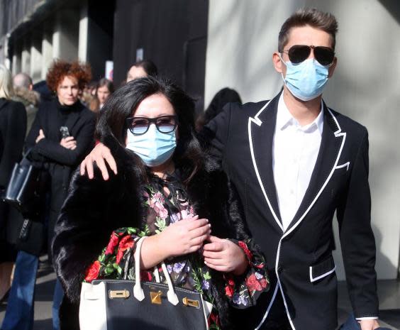 Guests wear face masks to protect against coronavirus upon arrival to attend the Dolce and Gabbana show during the Milan Fashion Week (EPA)