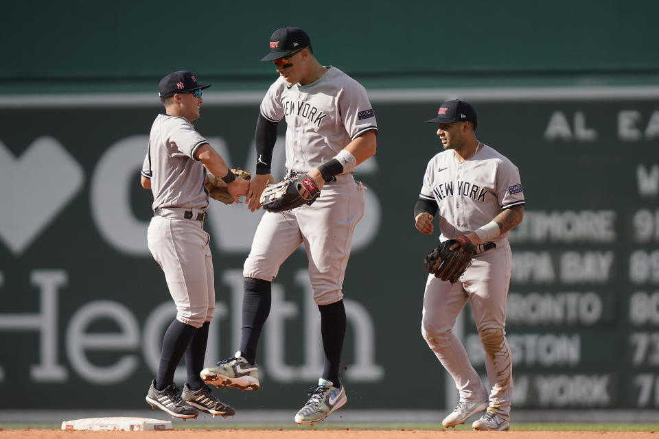 New York Yankees' Anthony Volpe, left, celebrates with Aaron Judge, center, after the Yankees beat the Boston Red Sox in the first game of a baseball doubleheader, Tuesday, Sept. 12, 2023, in Boston. (AP Photo/Steven Senne)