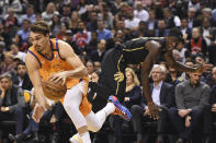 Phoenix Suns forward Dario Saric gets around Toronto Raptors forward Pascal Siakam during the first half of an NBA basketball game Friday, Feb. 21, 2020, in Toronto. (Frank Gunn/The Canadian Press via AP)