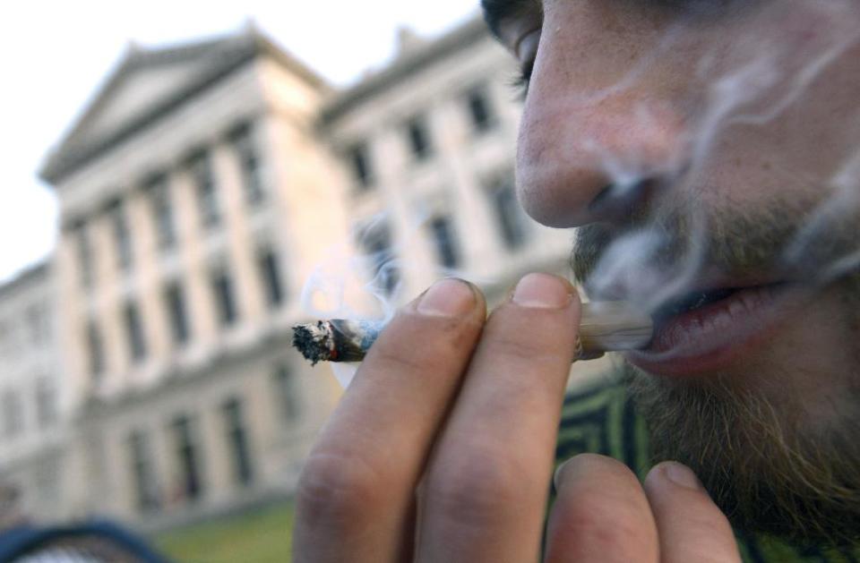 FILE - In this July 31, 2013 file photo, a man smokes a marijuana joint, while Senators debate a bill at the Senate to legalize marijuana and regulate production and distribution in Montevideo, Uruguay. From the Americas to Europe to North Africa and beyond, the marijuana legalization movement has unprecedented traction, a nod to successful efforts in Colorado, Washington, and the small South American nation of Uruguay, which in Dec. 2013, became the first country to approve nationwide pot legalization. (AP Photo/Matilde Campodonico, File)