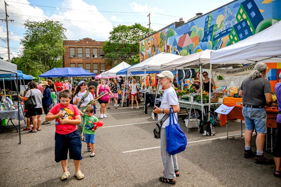 Patrons shop at the Allen Farmers Market which includes goods from local farms and artisans including Highwater Farms on Wednesday, July 17, 2024, in Lansing.