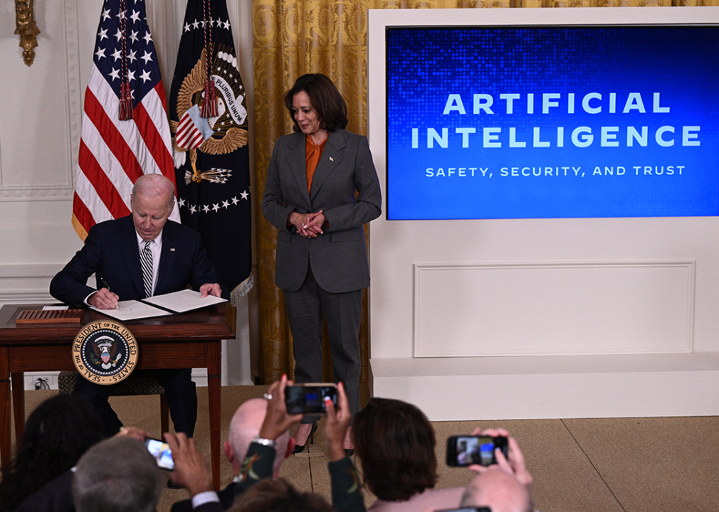 Kamala Harris looks on as Joe Biden signs an executive order regulating AI.