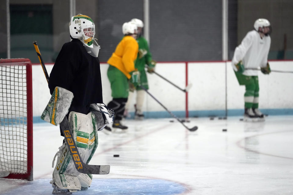 Evan Smolik stands by the goal during hockey practice Wednesday, Nov. 29, 2023, in Edina, Minn. When Evan was 14, a teammate's skate struck his neck and his jugular vein, but the neck guard he was wearing prevented the skate from cutting his carotid artery and helped save his life. (AP Photo/Abbie Parr)