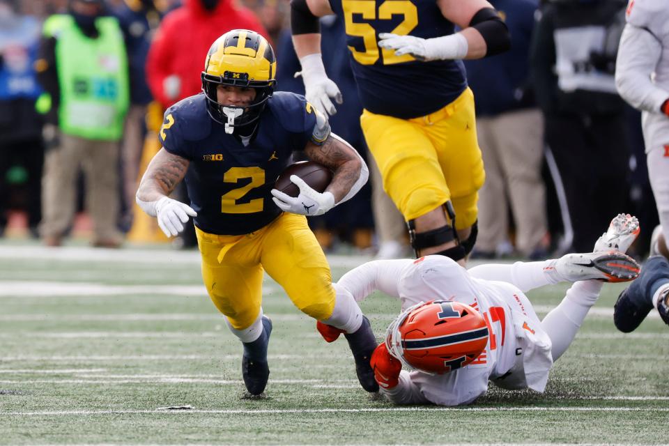 Michigan running back Blake Corum (2) is tackled by Illinois linebacker Calvin Hart Jr. (5) in the first half at Michigan Stadium.