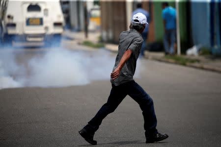 A man passes near riot security forces during protest against Venezuelan President Nicolas Maduro's government in Valencia, Venezuela August 6, 2017. REUTERS/Andres Martinez Casares