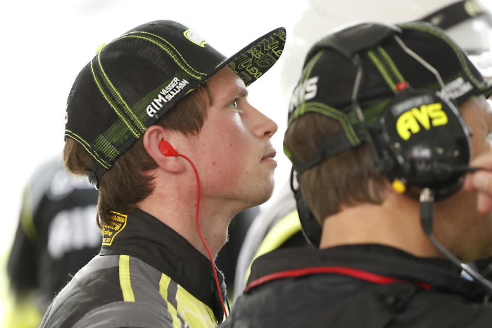 AIM Vasser Sullivan driver Frankie Montecalvo, left, looks at a monitor in the pits during practice for the Rolex 24 hour auto race at the Daytona International Speedway, in Daytona Beach Fla., on Thursday, Jan. 23, 2020. (AP Photo/Reinhold Matay)